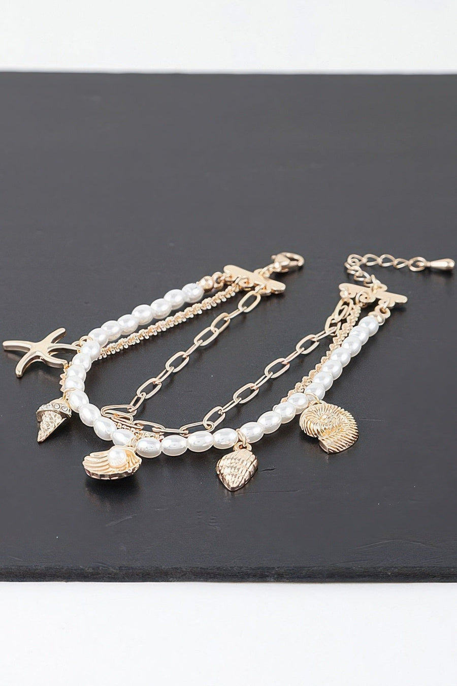 Close-up of the scallop shell charm set with a single pearl